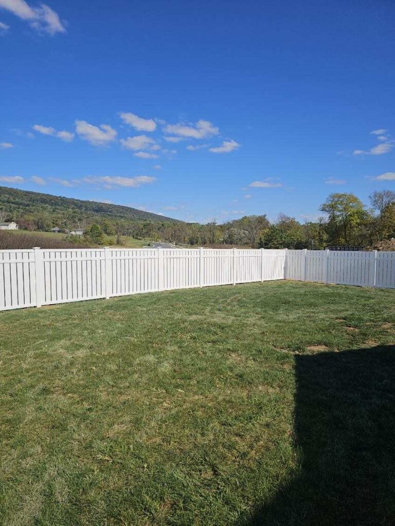 white vinyl fence in a big yard